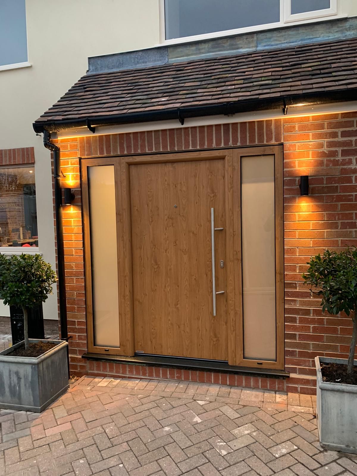 Hormann Thermo65 010 Finished in Winchester Oak, side elements to match with sand-blasted glass.